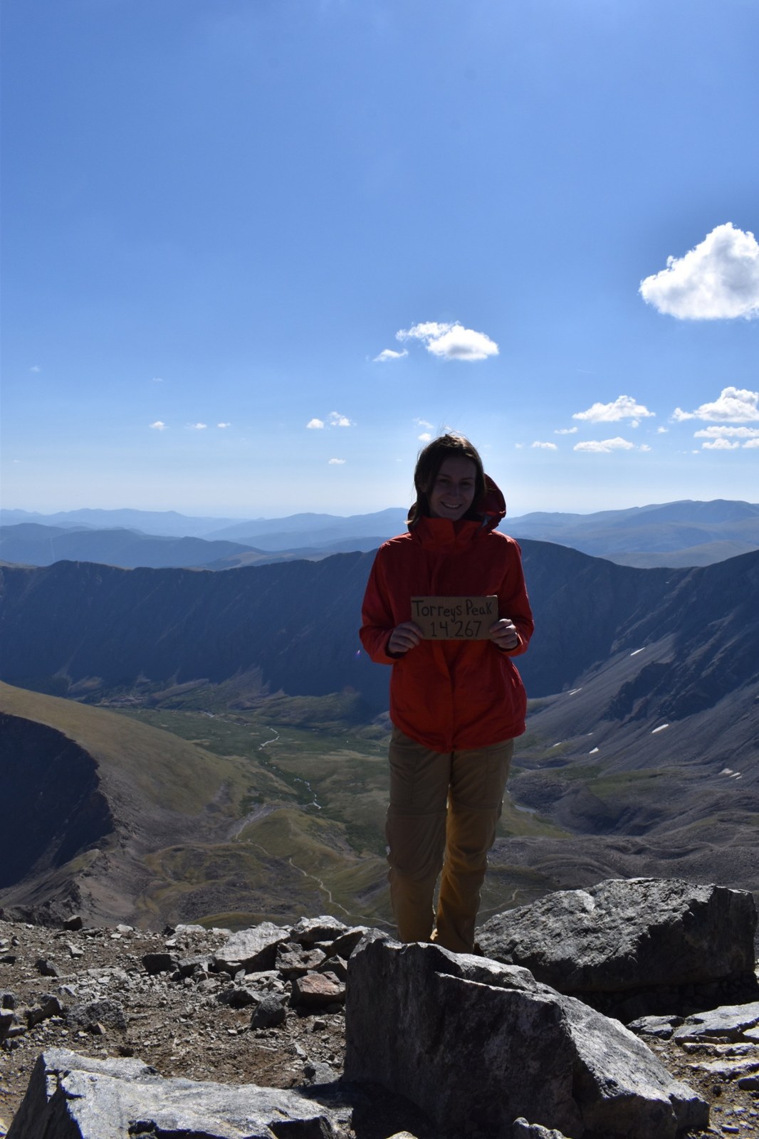 Amanda standing on a mountain summit