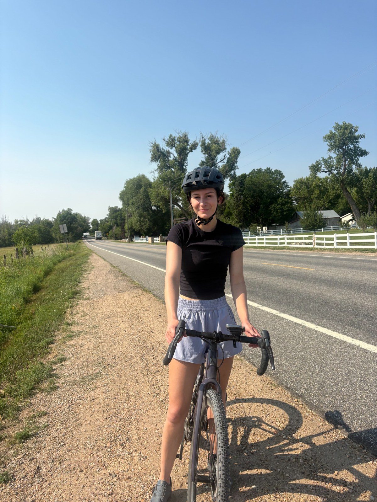 Amanda with her bicycle beside a trail